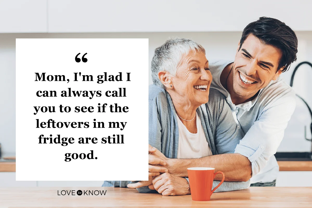 Senior woman and young man embracing in a domestic kitchen