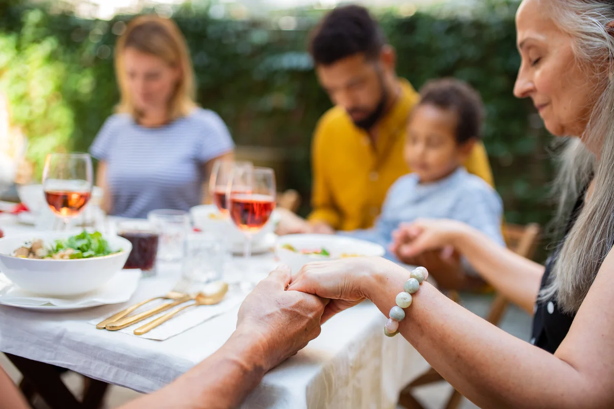 family holding hands prayer before Easter meal