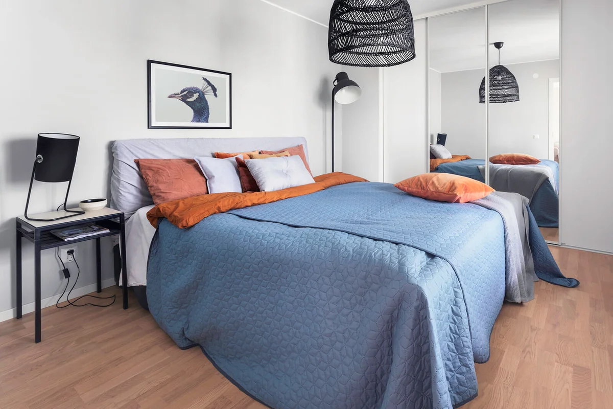 A bedroom with a double bed and a closet with sliding doors