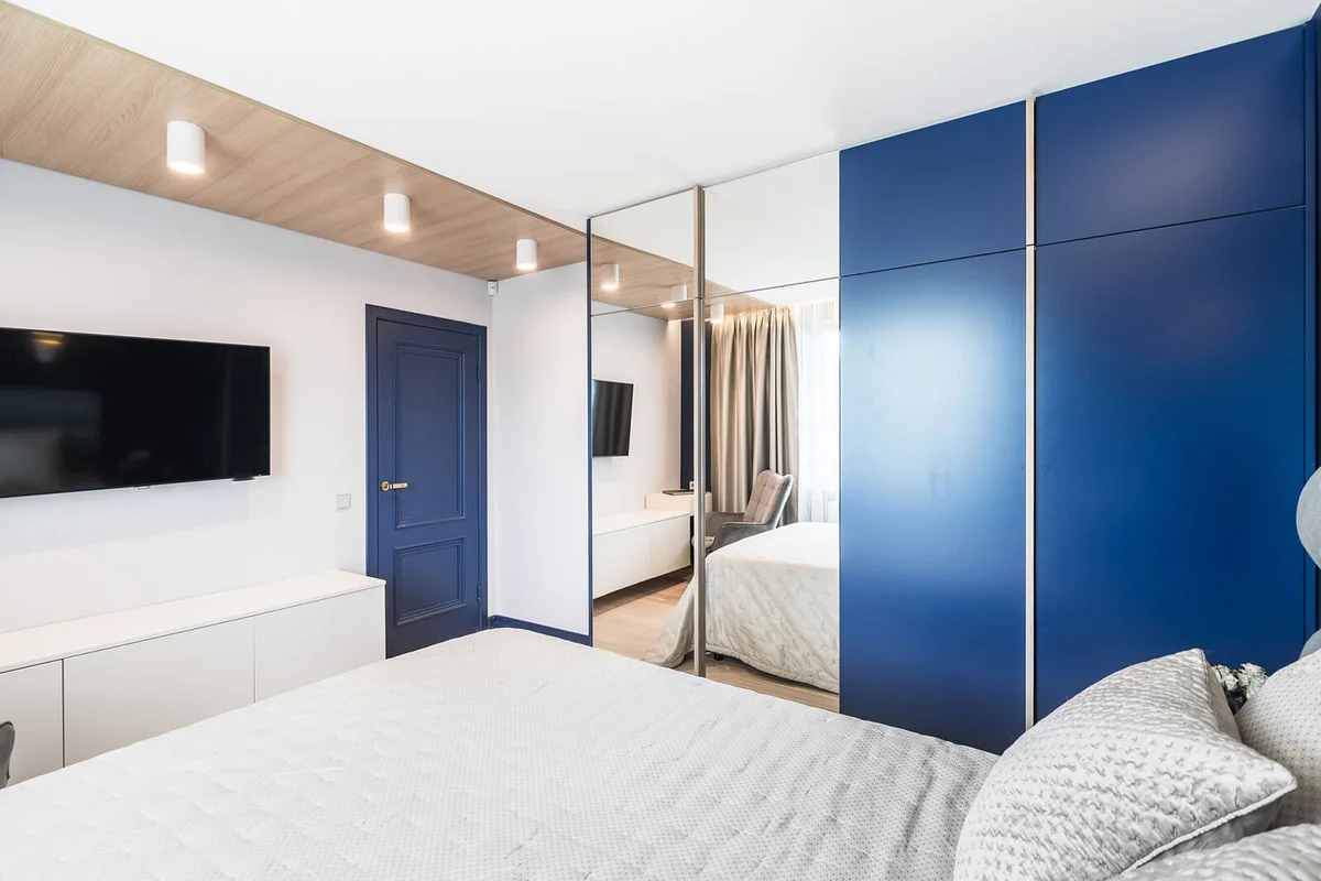 View to kingsize bed, TV and entrance in bright and cozy bedroom