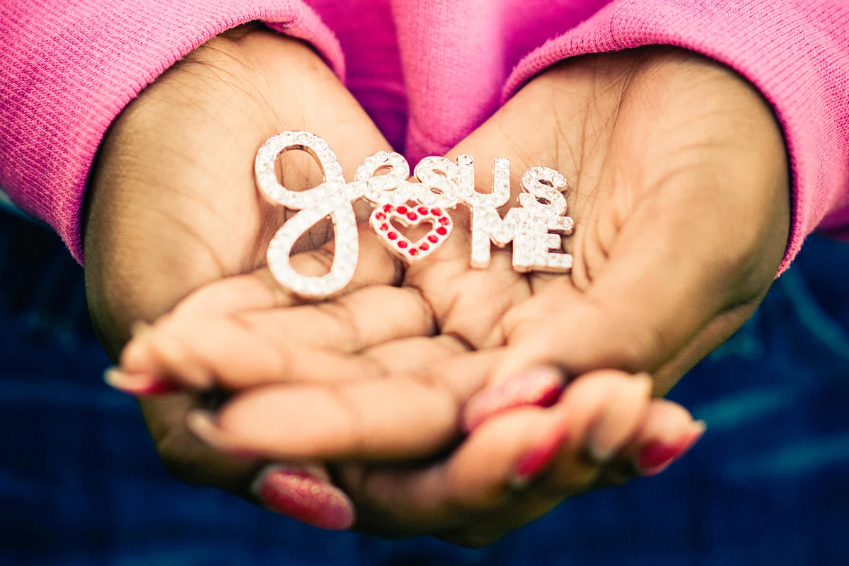 Teenage Hands Holding Jesus Loves Me Pin