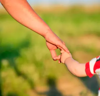 A child and an adult holding hands Image used under license from IstockPhoto