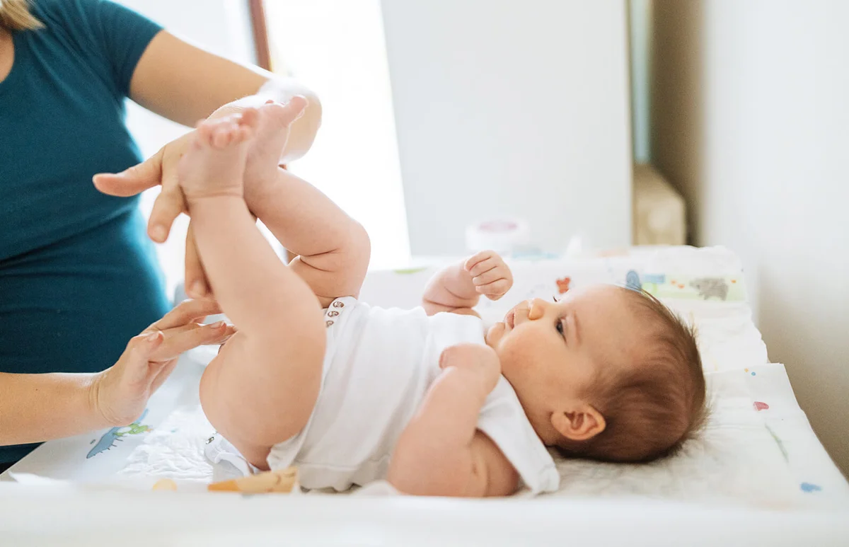 Mother cleaning baby and changing the baby clothes