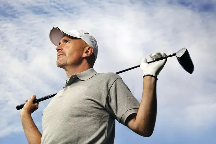 Golfer holds driver behind back
