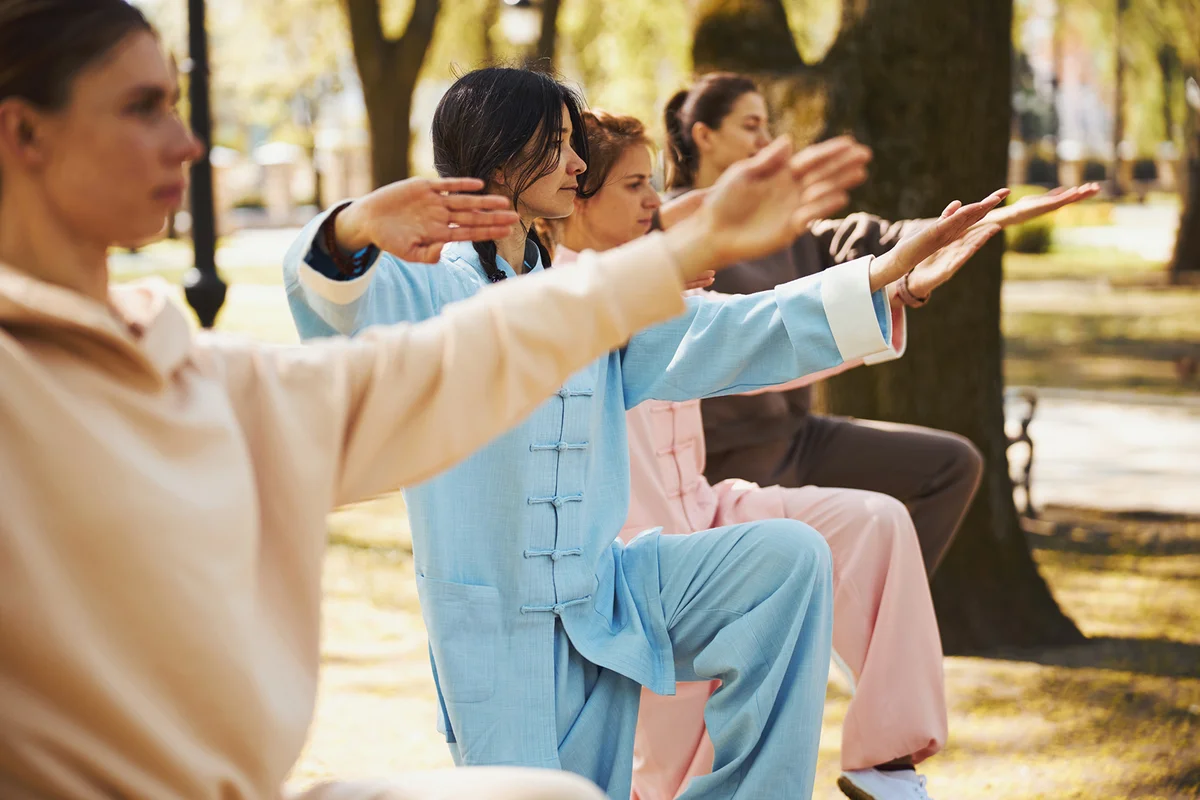 Women standing on one leg during tai chi lesson