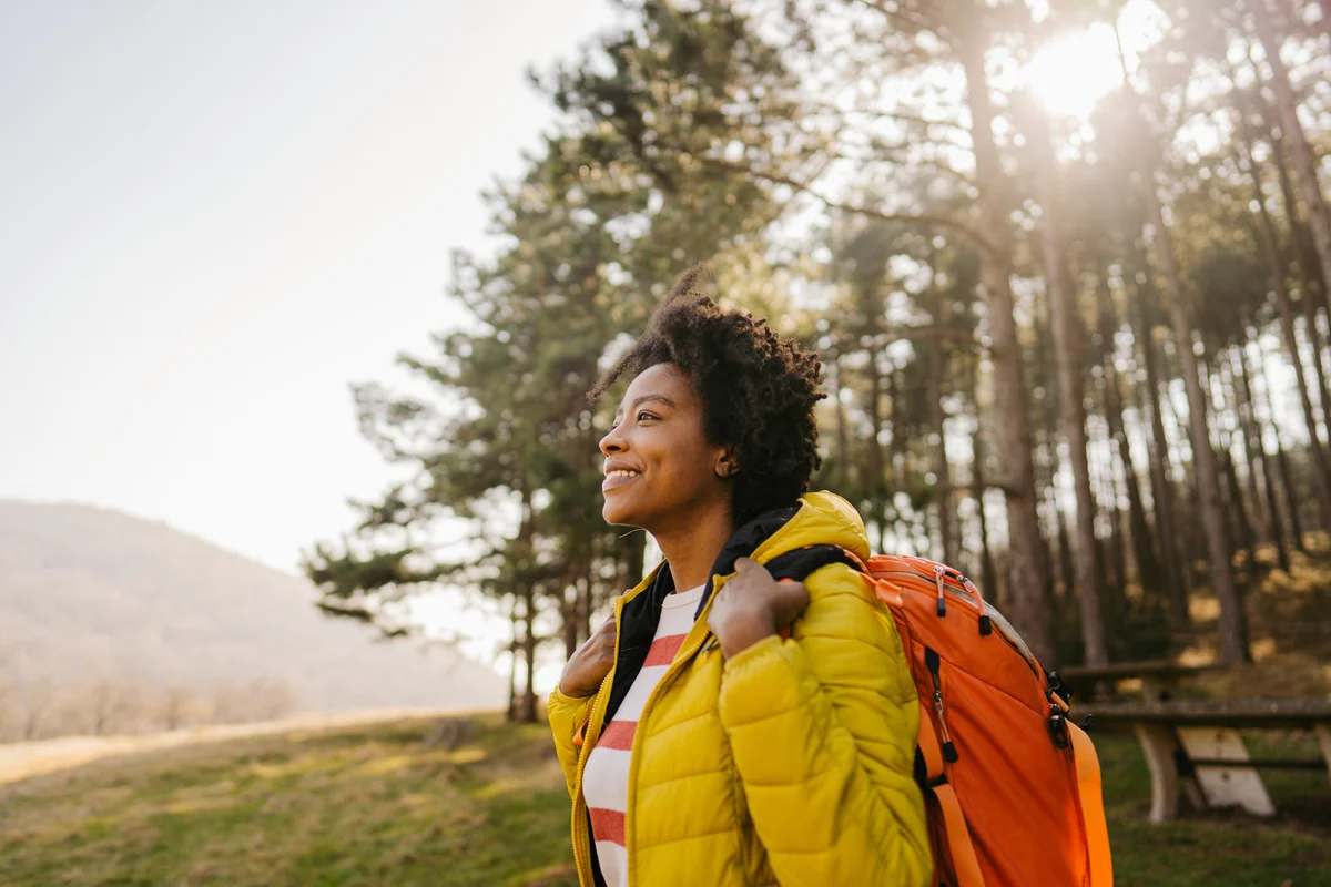 woman smiling while on a hike in the woods