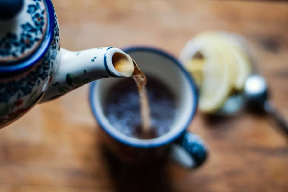 Kettle Pouring Tea In Cup