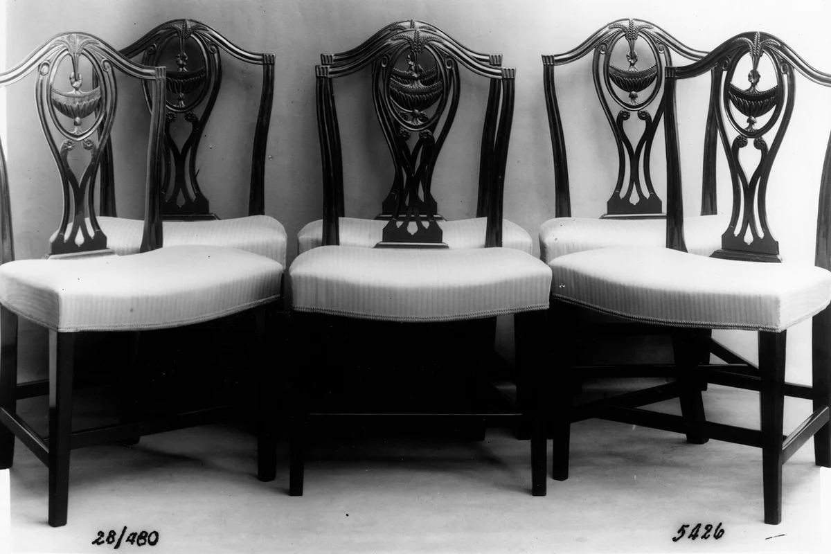 circa 1800: A set of six Hepplewhite-style dining chairs with wheat ear motifs, camel backs and curved serpentine seats. | Getty Editorial Use