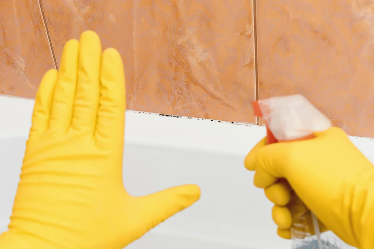 Hand showing stop mold in bathroom