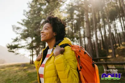 woman smiling while on a hike in the woods
