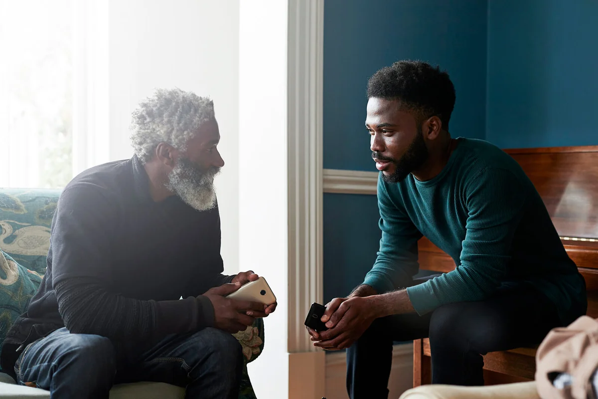 Male friends talking while sitting in living room