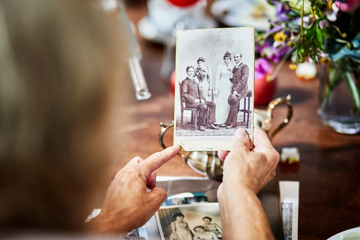 senior woman holding old black and white photo