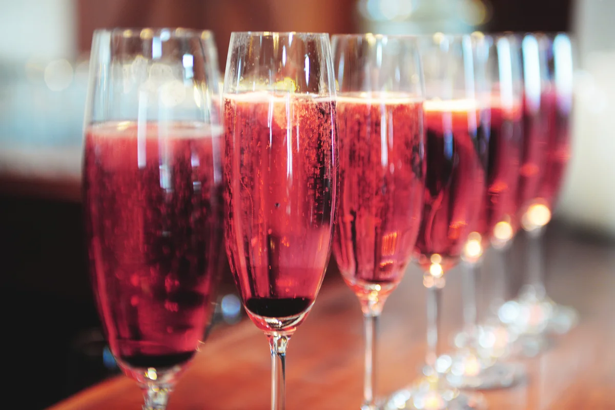 Red sparkling wine in champagne flutes in a row