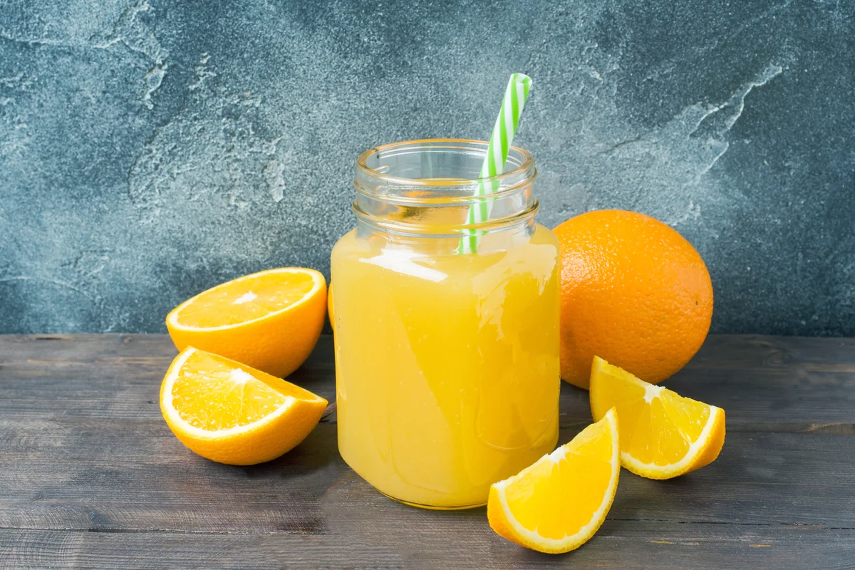 Orange infused vodka in glass jar and fresh fruits oranges