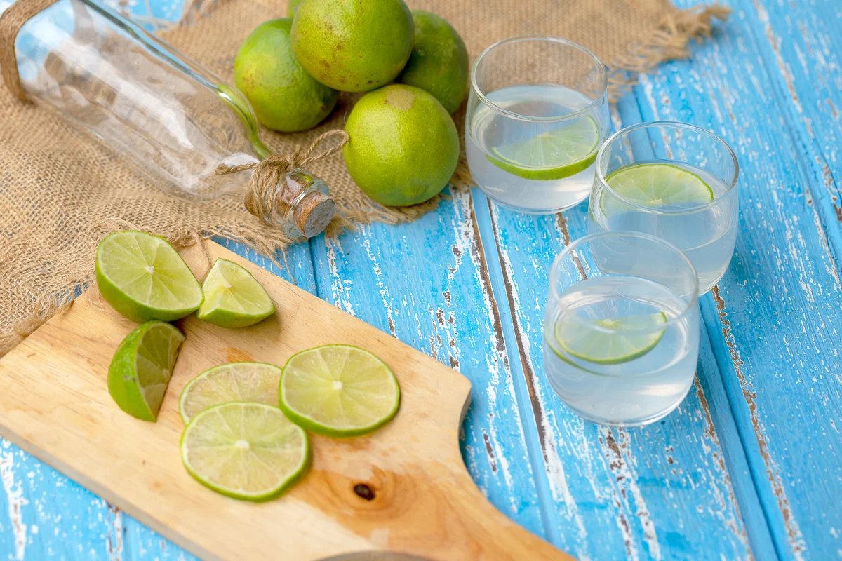 Lime juice and lemon on a blue wooden table