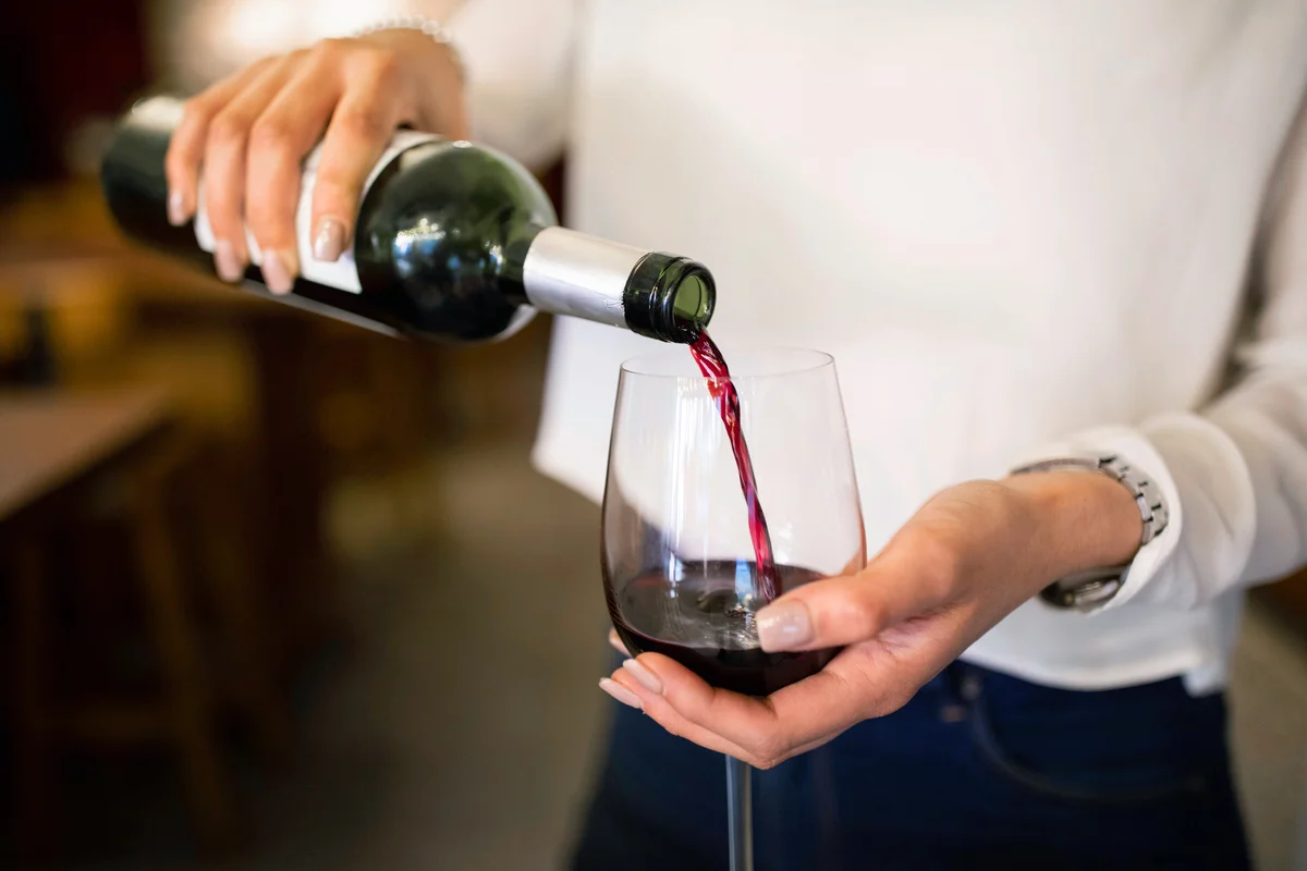 Woman serving red wine