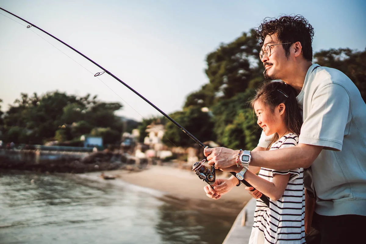Young family fishing together joyfully at pier