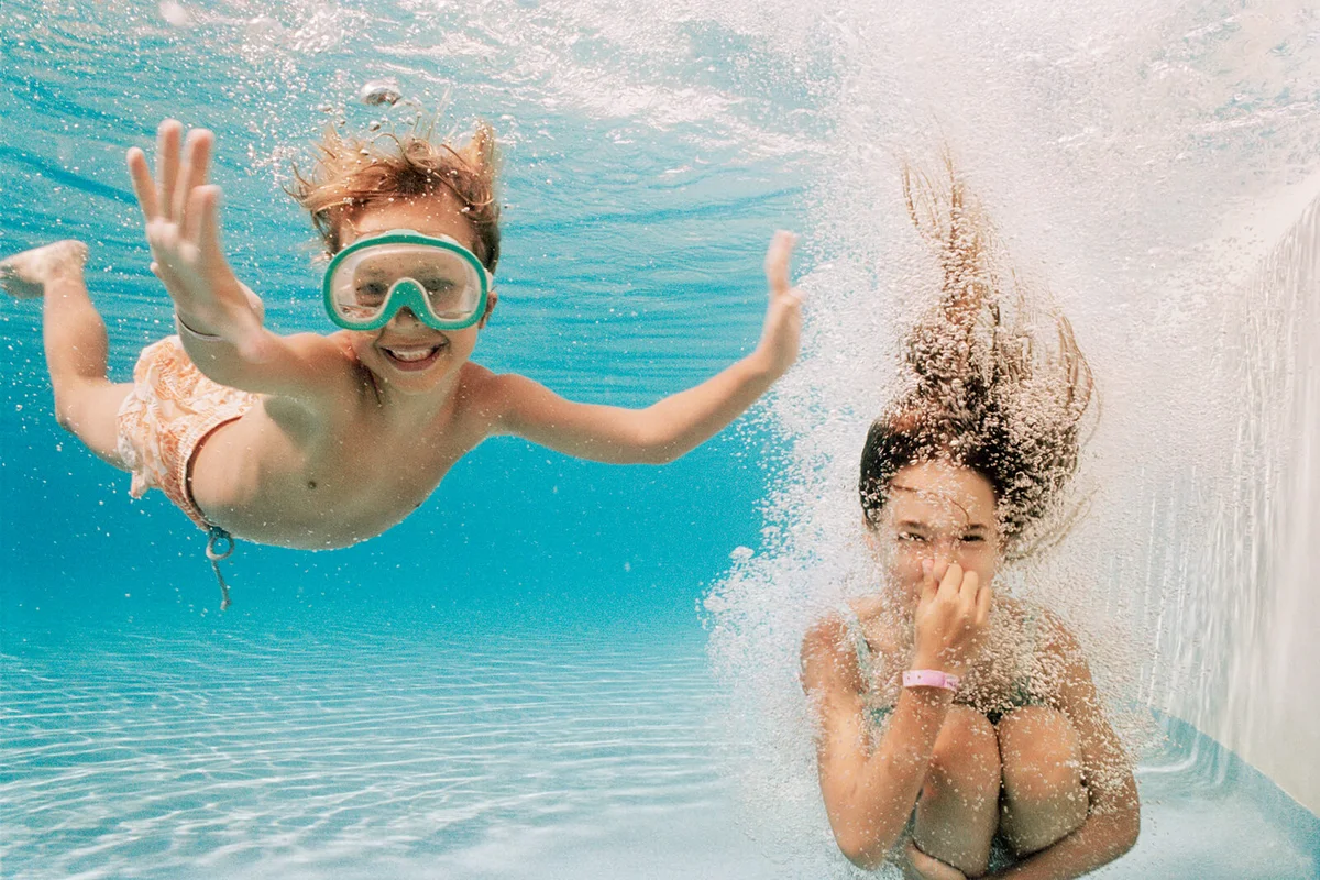 Girl and Boy Underwater in Swimming Pool