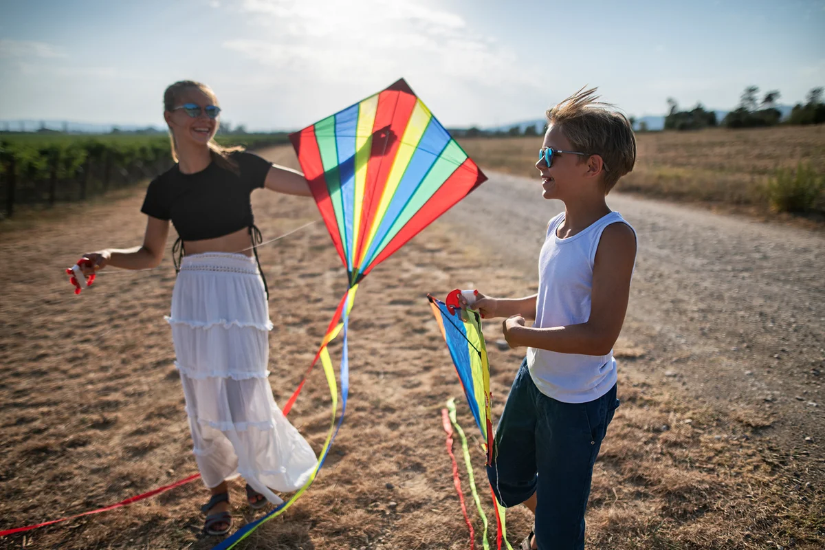 Teenagers flying kites on a sunny summer day