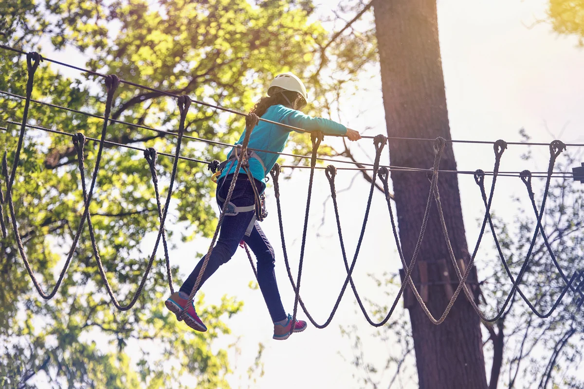 Teenager walking on ropes hanging on the heights