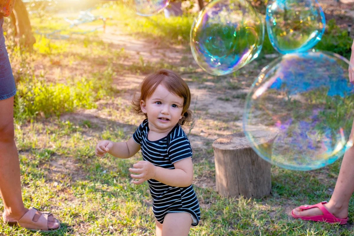 Toddler boy blowing soap bubbles