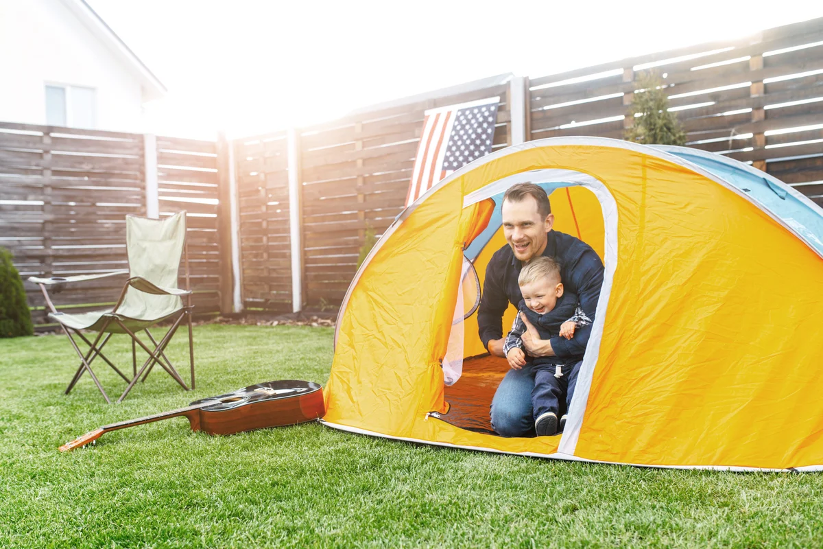 Father and toddler son camped in the backyard