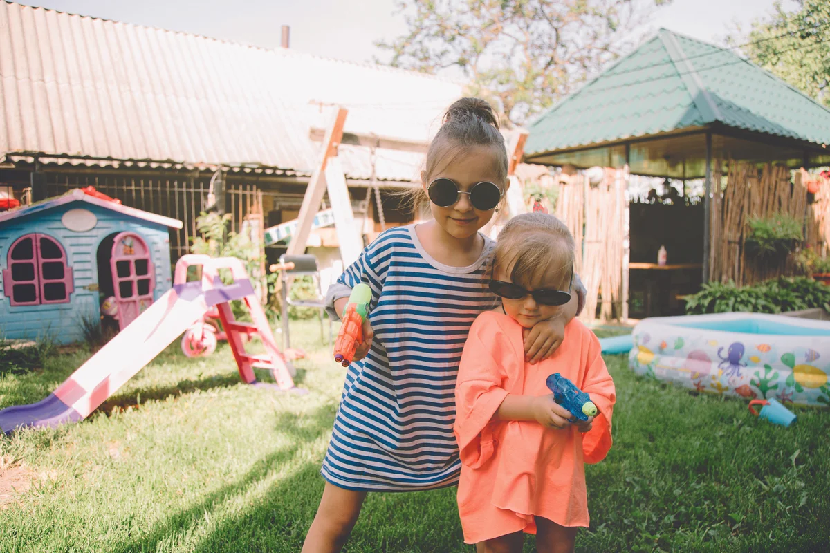 Little girls playing with water guns