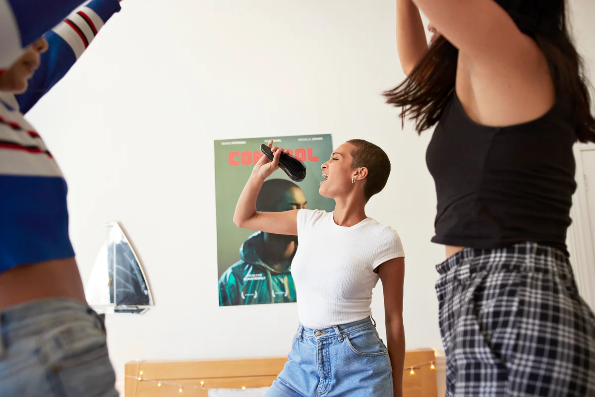 Young woman singing and dancing with friends