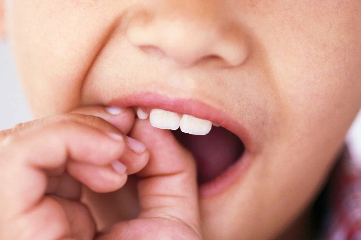 young boy wiggling loose tooth
