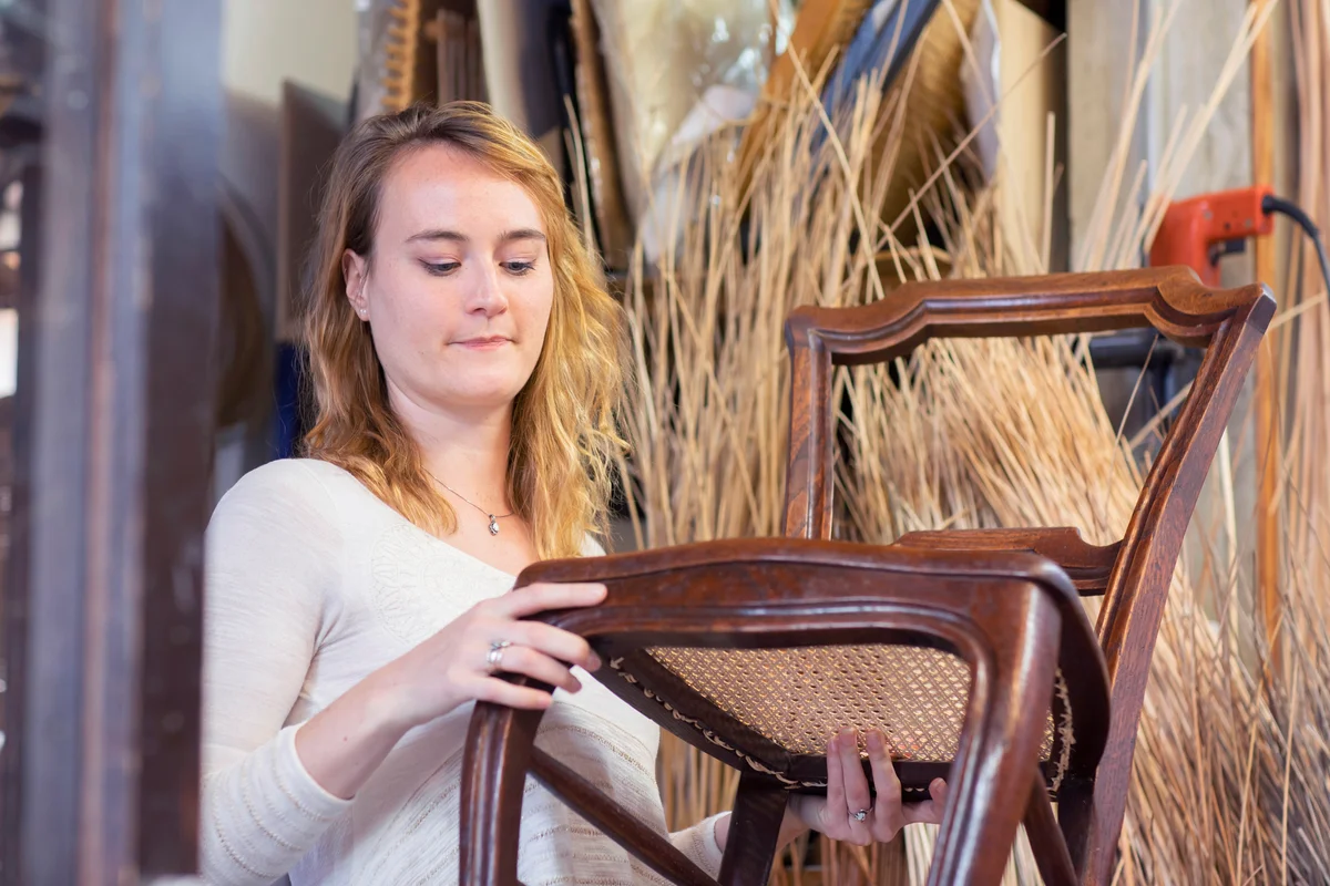 Young woman examining antique chair