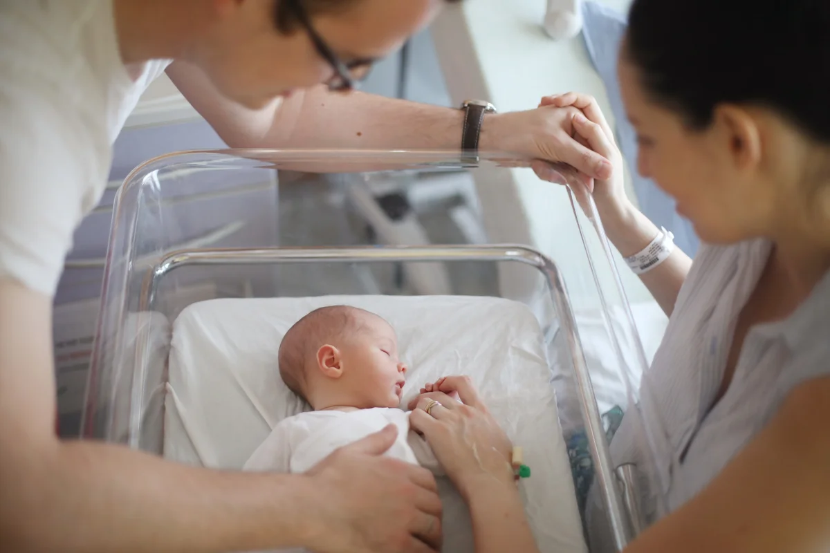 A newborn and his parents at the maternity ward - stock photo