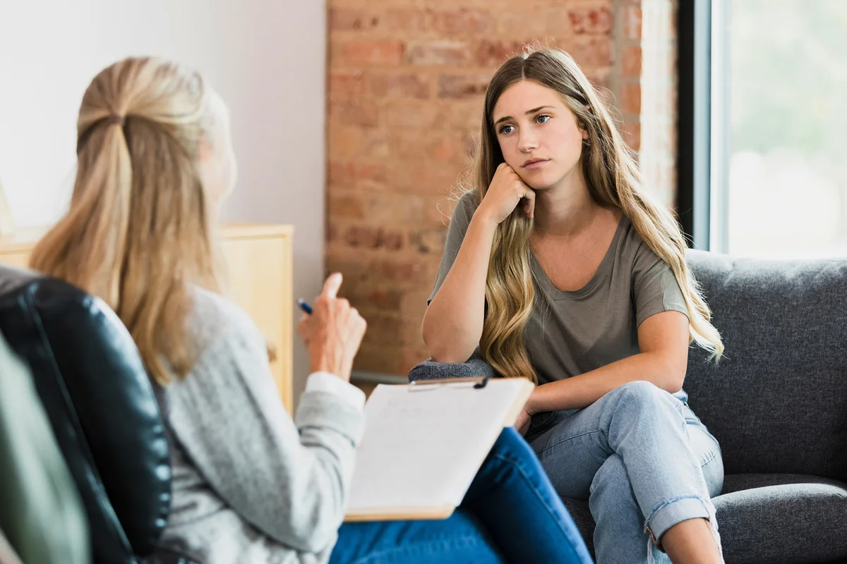 Teen listens to advice from therapist