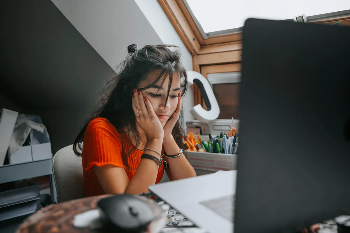 female teenager feeling stressed studing at home