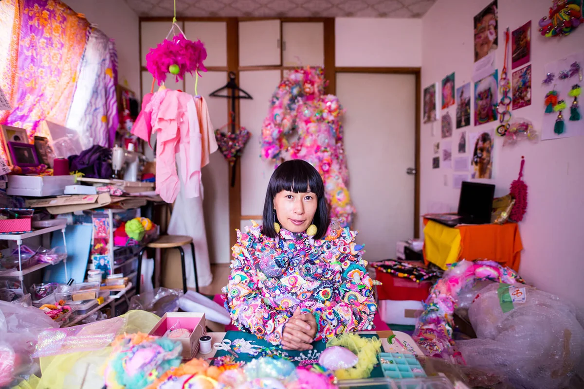 A female contemporary artist working in her studio creating art with textiles