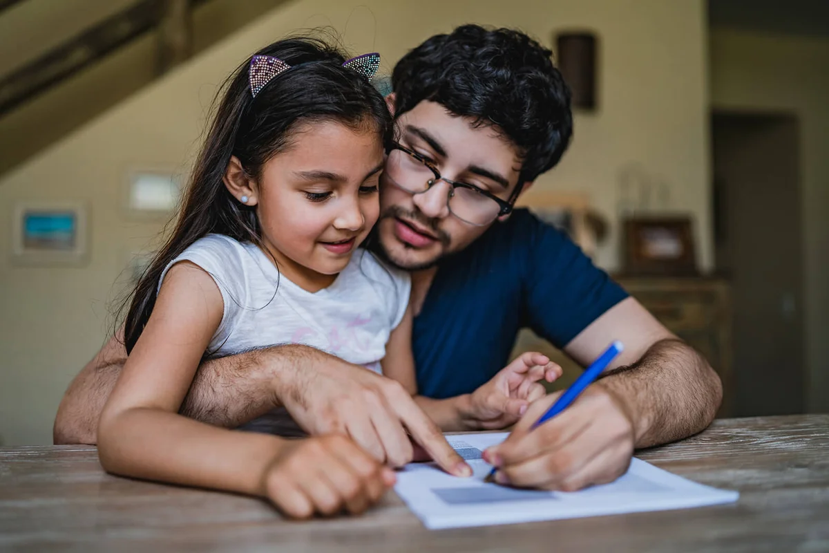 Man signing papers with daughter in his lap