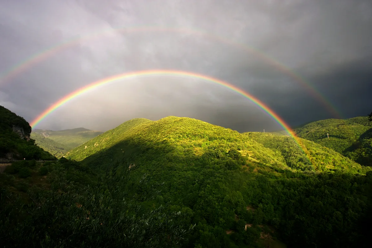 Double rainbow over rolling landscape