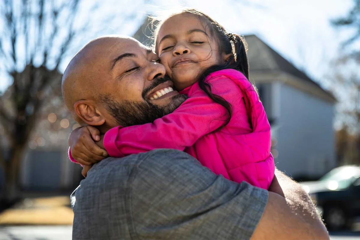 father hugging daughter