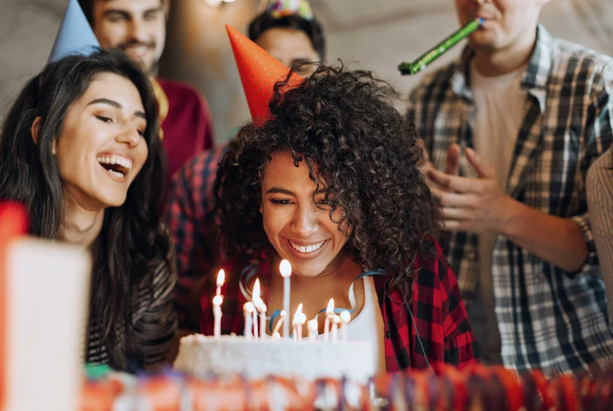 woman with friends smiling at birthday cake