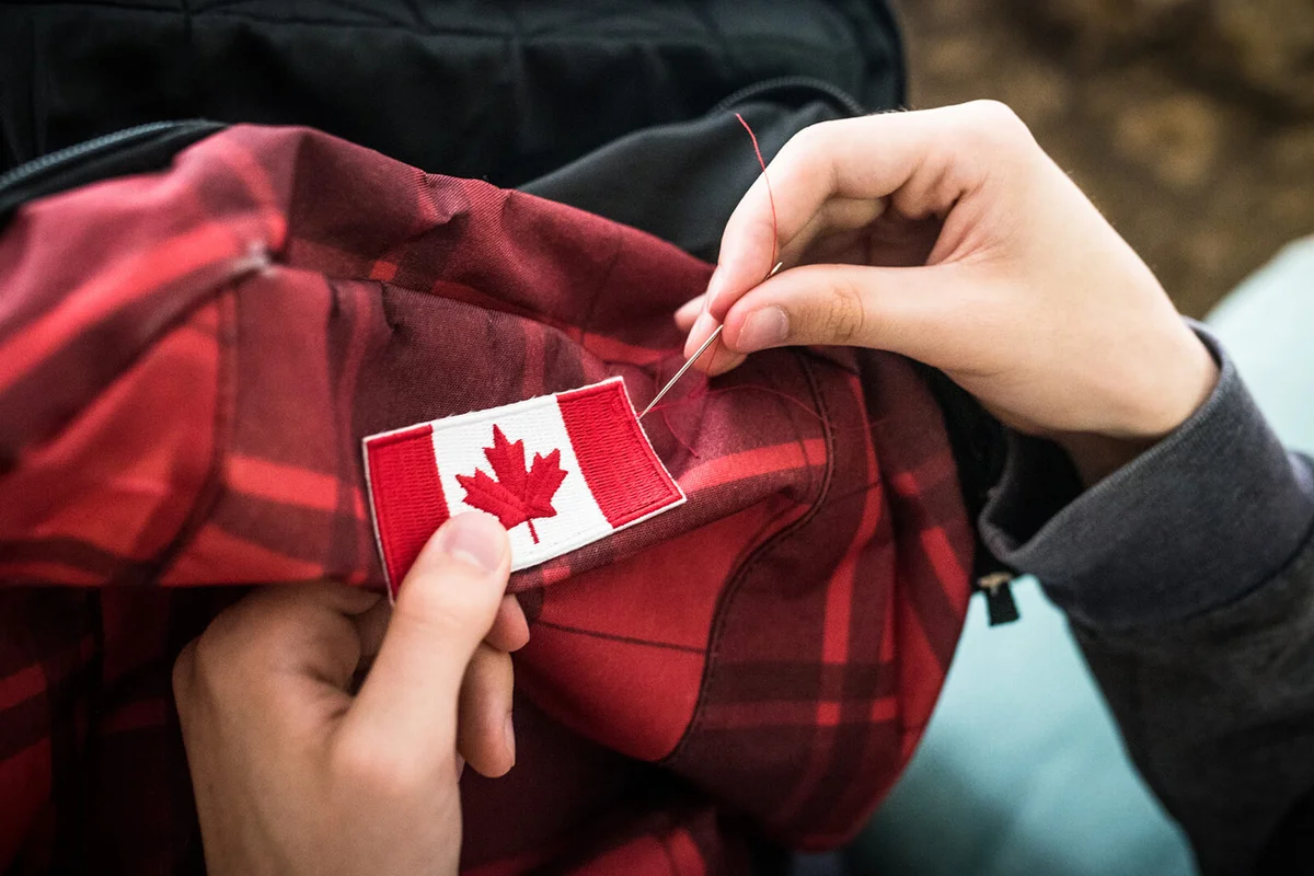 Sewing a Canadian flag onto a backpack for international travel