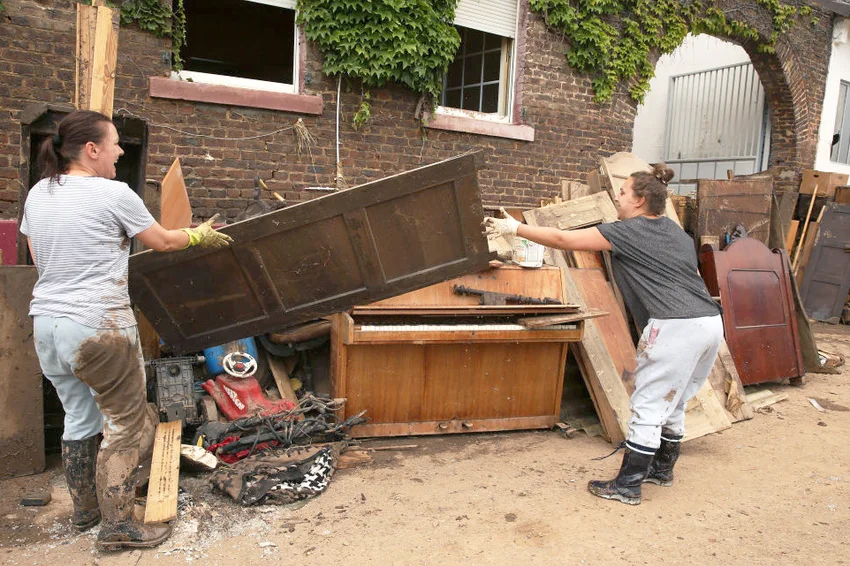 Employees of an antique furniture restoration workshop throw a door into a pile