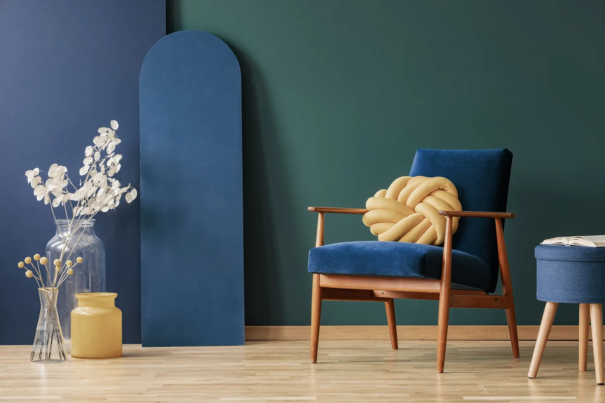 Navy blue and green flat interior with flowers and stool