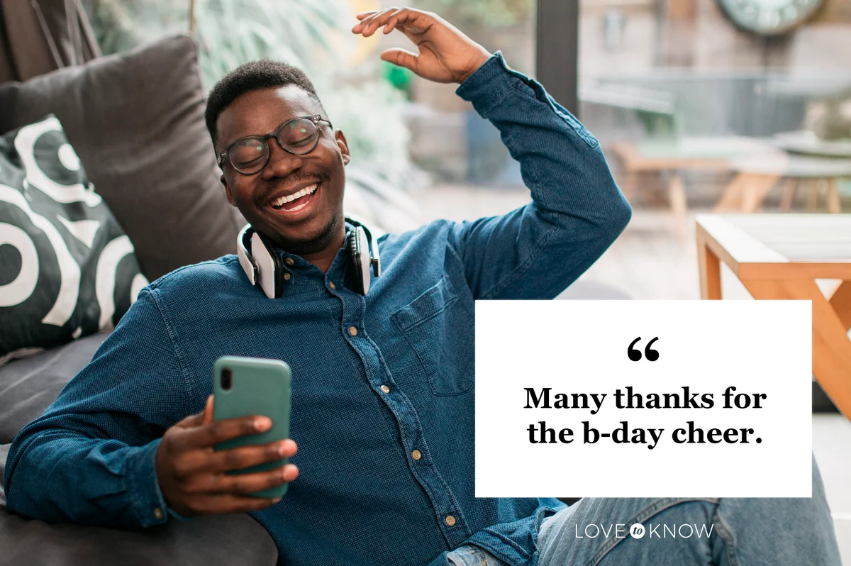 happy young man reading birthday wishes social media comments on his phone