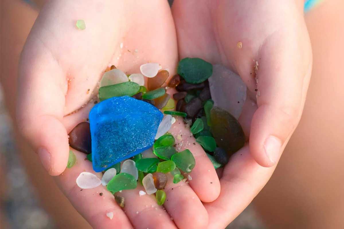child holding sea beach glass in hands
