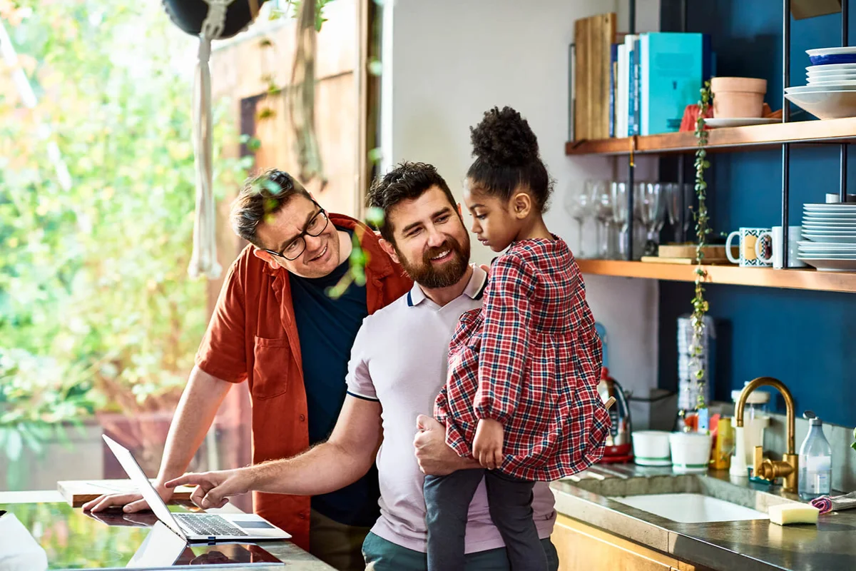 Gay couple online shopping with their daughter