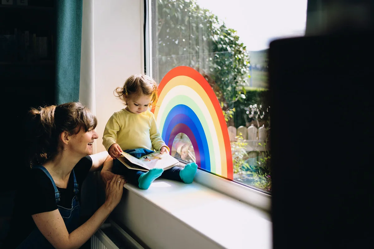 Toddler sat on windowsill reading book