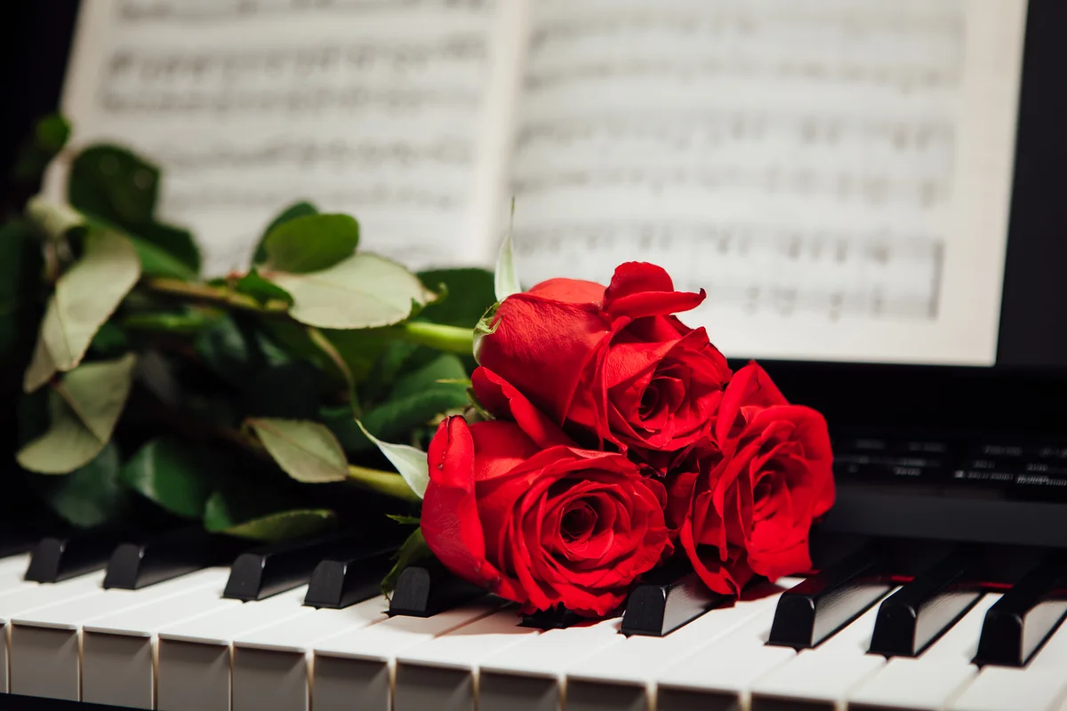 roses on church piano with hymnal for funeral music