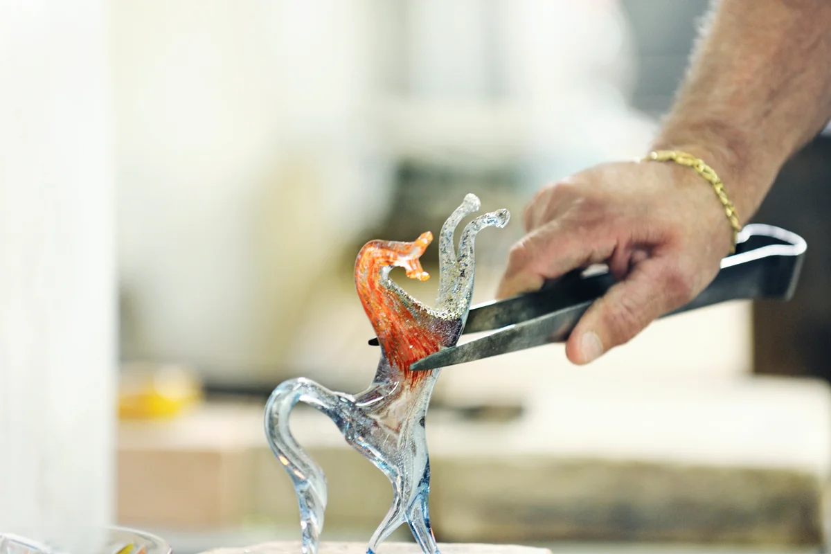 Glassmaker finishing horse ornament