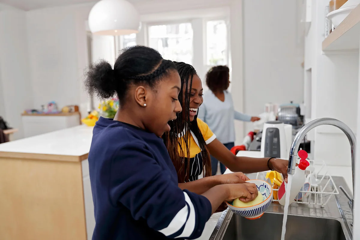 Two teenage girls washing dishes