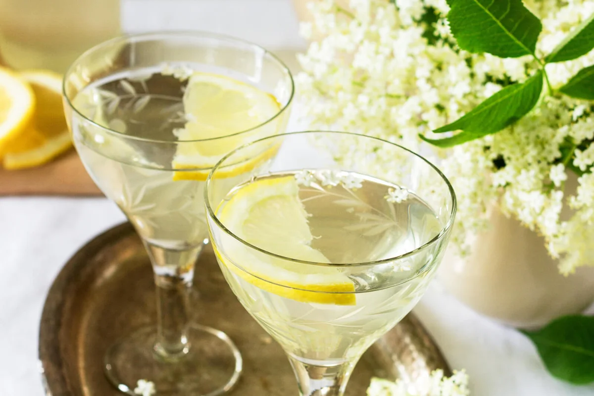 A Cool Drink With Lemon And Elderflower Syrup In Glasses On A Metal Tray