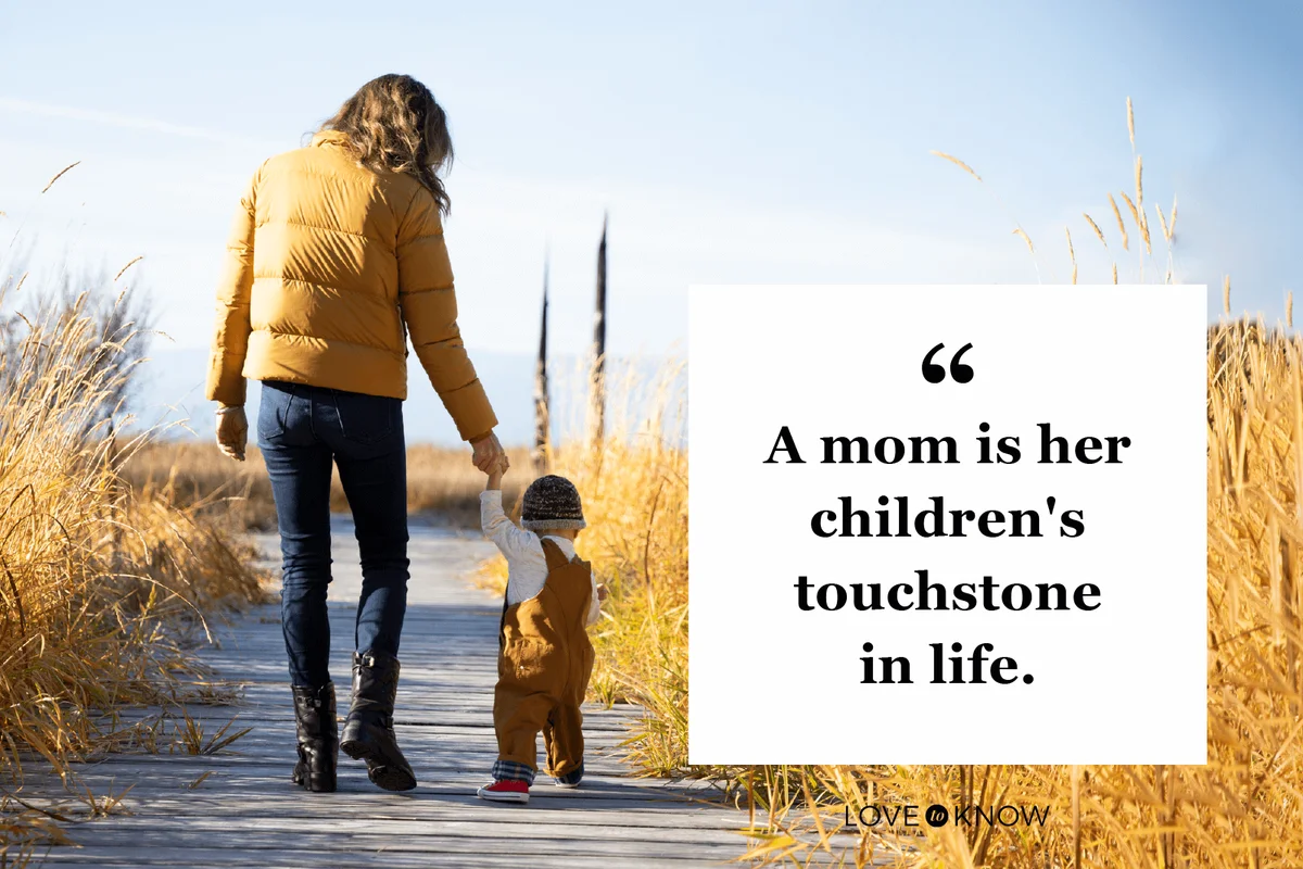 A young boy walking with his mother on a boardwalk
